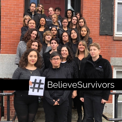 BARCC staff gathered in black with text overlay: #BelieveSurvivors