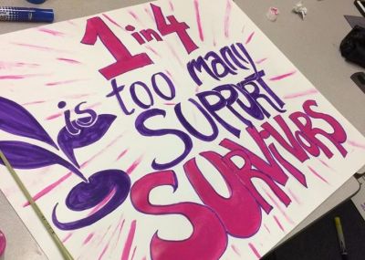 Purple and pink sign that says 1in 4 is too many, support survivors