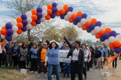 Gina Scaramella and Rep. Ayanna Pressley with balloon arch and huge group of walkers at the start of the Walk for Change